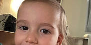 Emi participe au concours pour gagner de l'argent avec cette photo : child, toddler, smiling, indoors, person, face, hair, pony_tail, pink_clothing, wooden_beams, room, table, hand, happy, portrait, expression, casual, light, skin, closeup