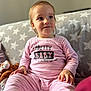 toddler, child, baby, pajamas, pink_stripes, sitting, soft_toy, blanket, star_pattern, indoor, portrait, cute, smiling, face, hand, cozy, young_child, clothing, comfort, expression