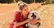 Archie a rejoint le concours — aidez-le/la à gagner de superbes lots ! woman, dog, outdoor, field, grass, trees, sunlight, smiling, hug, red_dress, polka_dot, happy, tongue_out, pet, nature, summer, crouching, canine, friendship, casual