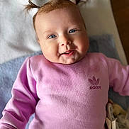 Lyna a rejoint le concours — aidez-le/la à gagner de superbes lots ! baby, child, pigtails, pink_clothing, adidas, smile, blue_eyes, happy, portrait, cute, infant, blanket, soft_texture, indoors, person, young_child, face, head, clothing, laying_down