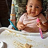 baby, camouflage, child, clothing, cute, face, feeding, food, hands, happy, high_chair, indoor, infant, meal, messy, pink, portrait, seat, smiling, spoon