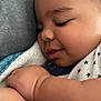 baby, sleeping, blanket, cozy, child, smile, face, arm, skin, closeup, comfort, soft, cute, infant, resting, peaceful, warm, clothing, indoors, portrait