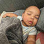 baby, sleeping, blanket, couch, pillow, infant, child, cozy, nap, indoors, relaxation, soft_texture, plush, peaceful, comfortable, face, skin, clothing, rest, home