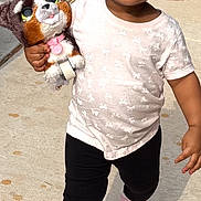 Zhuri joined the competition — help win amazing prizes! toddler, child, smiling, walking, stuffed_animal, toy, sidewalk, outdoor, casual_clothing, pink_shoes, black_pants, short_sleeve_shirt, happy, sunlight, person, young_child, cute, daytime, playful, holding