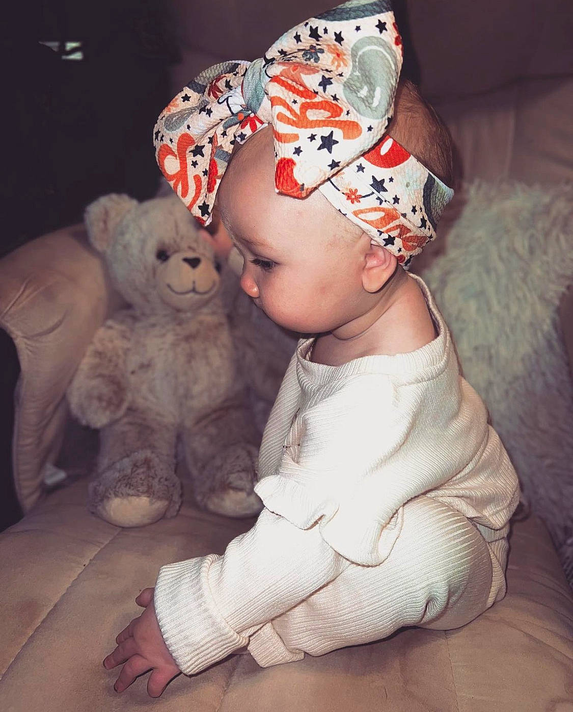 Ensley is registered to the contest to win money with this photo: art, baby, baby_toddler_clothing, cap, child, costume_hat, fashion_accessory, fictional_character, flooring, fur, hat, head, headband, headpiece, pattern, person, sitting, teddy_bear, textile, toddler