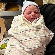Zaylee is registered to the contest to win money with this photo: newborn, baby, blanket, hat, sleeping, indoor, person, face, human, clothing, pattern, striped, hospital, comfort, holding, resting, curtain, footwear, floor, seated