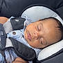 baby, sleeping, car_seat, child, infant, stripes, safety_harness, closeup, face, peaceful, resting, young_child, seatbelt, cushion, comfort, indoors, cute, portrait, small_child, head_support