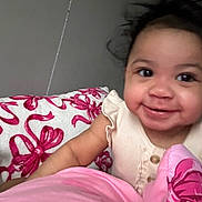 Jaliyah is registered to the contest to win money with this photo: baby, smiling, child, blanket, pink, white, bow_pattern, cute, happy, indoor, portrait, infant, face, clothing, cozy, warm, comfort, young, toddler, cute_expression