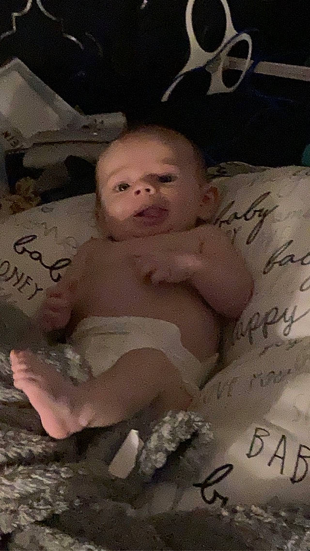 Grayson is registered to the contest to win money with this photo: abdomen, baby, baby_products, barechested, chest, child, event, font, handwriting, happy, linens, monochrome, paper_product, person, petal, photo_caption, room, toddler, trunk, writing