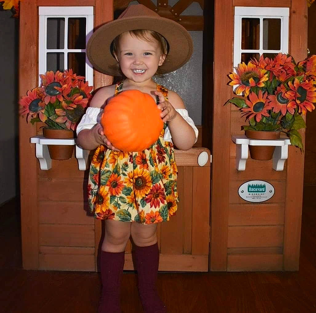 Oaklyn is registered to the contest to win money with this photo: calabaza, cucurbita, door, flower, flowerpot, gourd, happy, hat, houseplant, joy, local_food, natural_foods, orange, peach, person, plant, pumpkin, smile, sun_hat, whole_food