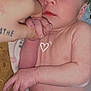 baby, newborn, infant, hand, finger, skin, diaper, person, closeup, love, heart_doodle, tattoo, blanket, sleeping_area, cuddle, care, soft_light, expression, cute, tender_moment