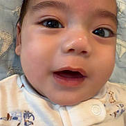 Michael is registered to the contest to win money with this photo: baby, infant, face, closeup, portrait, big_eyes, smiling, onesie, button, blanket, cheeks, cute, mouth_open, nose, eyebrows, skin, indoor, lying_down, bedding, happy