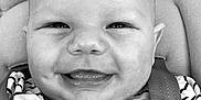 Capucine participe au concours pour gagner de l'argent avec cette photo : baby, smile, face, child, striped_shirt, car_seat, seatbelt, happy, infant, closeup, portrait, cute, black_and_white, apparel, person, young_child, head, expression, sitting, joyful