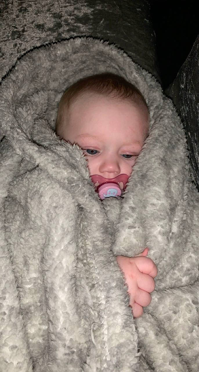 Isla-mae is registered to the contest to win money with this photo: baby, cheek, chin, close_up, comfort, eye, eyebrow, face, facial_expression, fur, gesture, grey, happy, head, iris, linens, nose, person, skin, textile