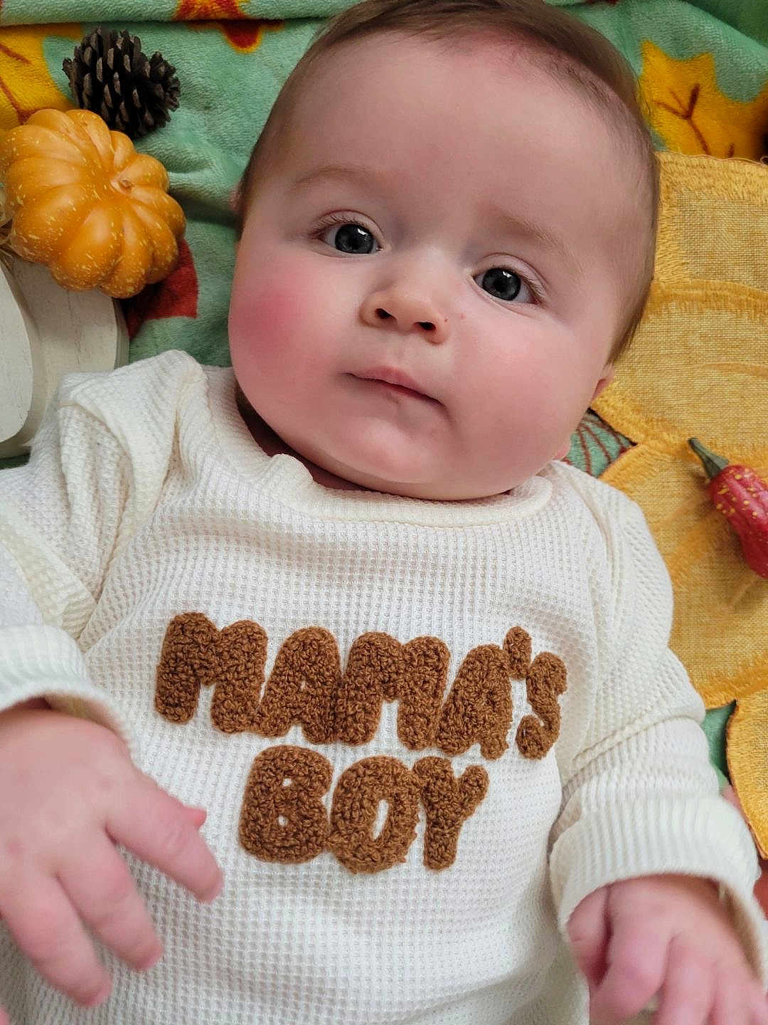 Archer joined the competition — help win amazing prizes! baby, infant, child, face, hands, clothing, shirt, text, blanket, pumpkin, pinecone, autumn, fall, cozy, cute, portrait, indoor, soft, decor, lying_down