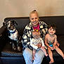 Barkley joined the competition — help win amazing prizes! baby, bottle, child, clothing, couch, dog, family, footwear, happy, holding, home, indoor, leather, pet, plaid, portrait, shirtless, sitting, smiling, woman
