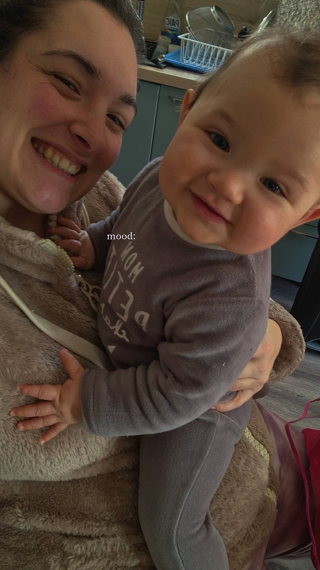 baby, bodypart, clothing, couch, face, finger, furniture, hand, happy, head, hoodie, knitwear, longsleeve, person, photography, portrait, sleeve, smile, sweater, sweatshirt