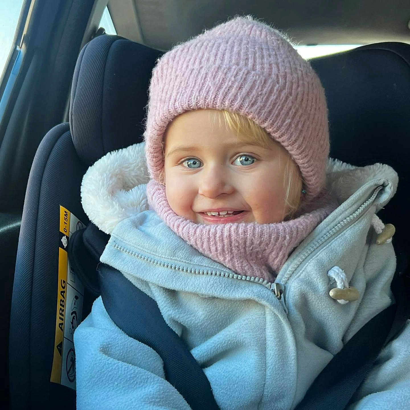 Béryl participe au concours pour gagner de l'argent avec cette photo : baby, blue_eyes, car_interior, car_seat, child, child_protection, cozy, cute, happy, indoor, jacket, knit_hat, portrait, scarf, seatbelt, sitting, smile, toddler, warm_clothing, winter_clothing