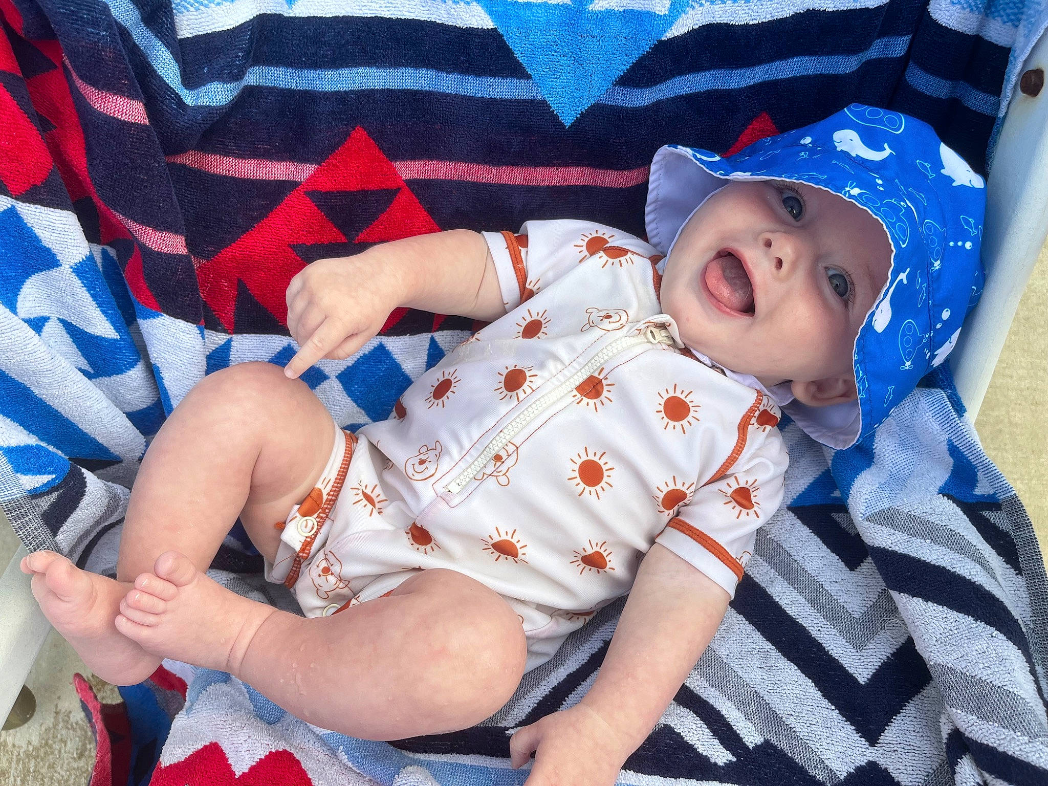 Atlas is registered to the contest to win money with this photo: baby, baby_products, baby_sleeping, baby_toddler_clothing, child, comfort, elbow, electric_blue, hat, headwear, human_leg, knee, linens, pattern, person, plaid, sitting, skin, sleeve, textile