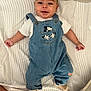 baby, infant, denim_overalls, mickey_mouse, smiling, striped_socks, white_tshirt, bedspread, striped_bedspread, cute, happy, lying_down, child, portrait, clothing, fabric, home, person, soft_toys, comfort