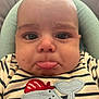 baby, close_up, face, pout, tongue_out, striped_clothing, whale_applique, cushion, infant, cute, child, expression, soft_lighting, indoors, portrait, young_child, seated, head, skin, eyelashes