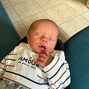 Raphaël participe au concours pour gagner de l'argent avec cette photo : newborn, baby, sleeping, infant, striped_clothing, finger, hand, face, closed_eyes, indoor, tile_floor, couch, text_on_clothing, cozy, resting, person, cute, small, child, relaxed
