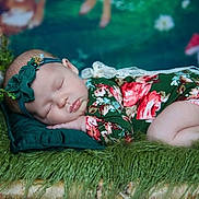 Remmie is registered to the contest to win money with this photo: baby, sleeping, floral_outfit, headband, green, pillow, fur, forest_theme, background, peaceful, infant, cute, portrait, child, nature, decor, soft_texture, resting, newborn, cozy