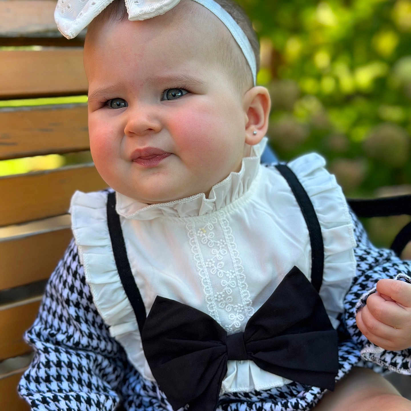 Amelia is registered to the contest to win money with this photo: accessories, baby, bench, blouse, clothing, coat, costume, dress, face, formalwear, furniture, hat, head, jacket, person, photography, portrait, shirt, sitting, tie