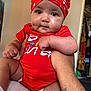 arm, baby, child, chubby, closeup, cute, diaper, expression, hand, headwrap, holding, human, indoors, infant, person, polka_dot, portrait, red_clothing, skin, tattoo