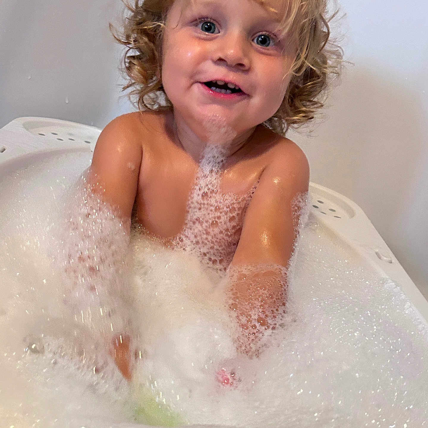 Keïzael participe au concours pour gagner de l'argent avec cette photo : bath, bathtub, bubbles, child, curly_hair, cute, foam, fun, happy, indoors, joyful, person, playful, skin, smile, splashing, toddler, water, wet, young