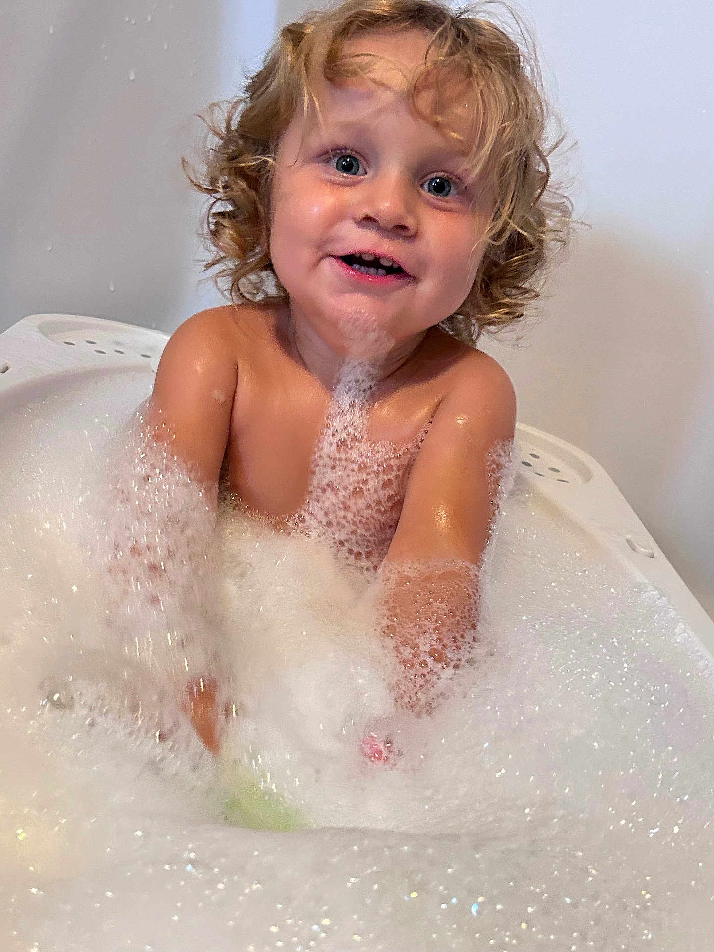 Keïzael participe au concours pour gagner de l'argent avec cette photo : child, toddler, bath, foam, bubbles, curly_hair, happy, water, splashing, playful, skin, indoors, bathtub, smile, young, fun, cute, wet, joyful, person