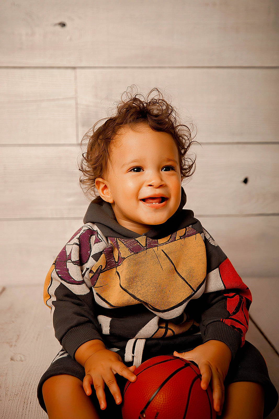Cyrus is registered to the contest to win money with this photo: arm, baby, baby_toddler_clothing, ball, basketball, child, eye, face, flash_photography, flooring, foot, fun, happy, human_leg, joy, knee, leg, person, sitting, smile
