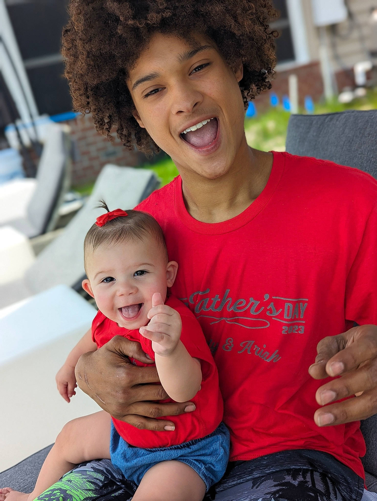 Ariah is registered to the contest to win money with this photo: arm, blue, clothing, face, facial_expression, fun, hair, hairstyle, hand, happy, human, jheri_curl, leisure, muscle, organ, person, photograph, product, shorts, shoulder