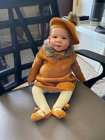 Ariah joined the competition — help win amazing prizes! baby, baby_toddler_clothing, beanie, cap, child, doll, fashion_accessory, flooring, fur, headwear, human_leg, kitchen_appliance, knee, knit_cap, person, room, sitting, sleeve, stuffed_toy, tableware