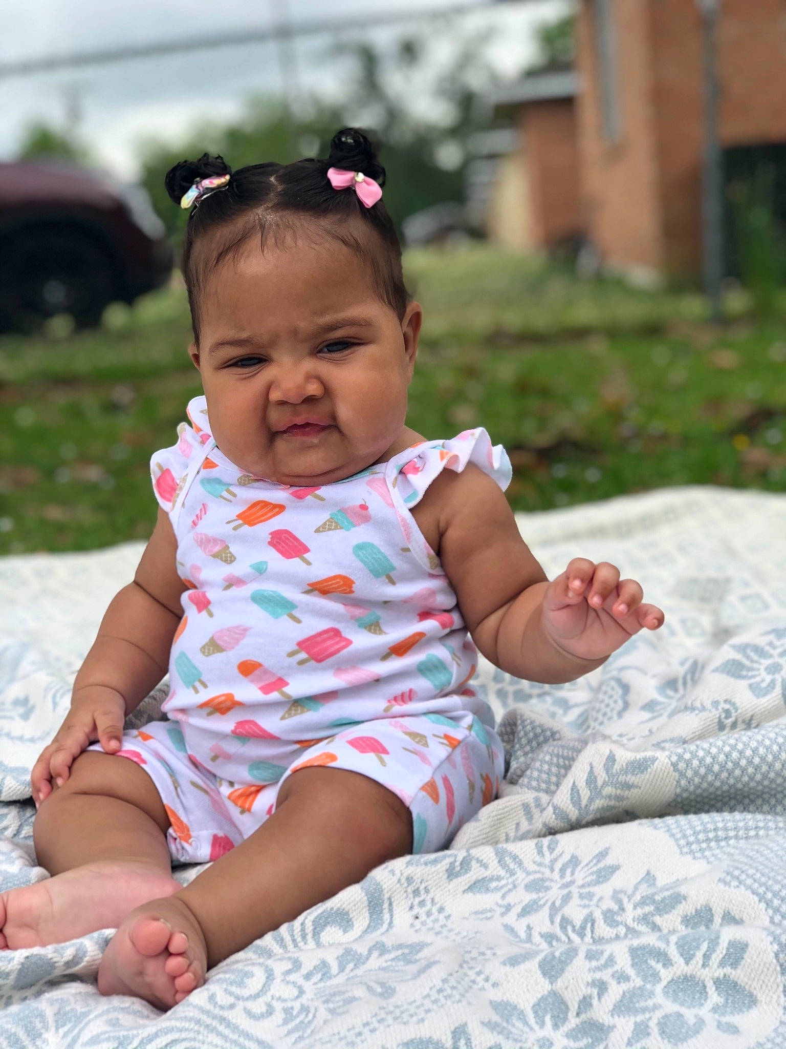 Marlee is registered to the contest to win money with this photo: baby, baby_toddler_clothing, child, comfort, dress, fun, grass, happy, human_leg, leisure, linens, pattern, person, pink, plant, recreation, sitting, skin, sleeve, thigh