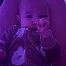 Emorie is registered to the contest to win money with this photo: baby, infant, onesie, bear_pattern, thumb_sucking, purple_light, indoor, cozy, cute, sleepwear, person, child, portrait, soft_lighting, nighttime, lights, relaxing, young, face, comfort