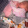 baby, sleeping, blanket, pillow, floral_pattern, bed, cozy, infant, child, soft, comfort, rest, peaceful, clothing, indoors, portrait, cute, toddler, sleepwear, nursery