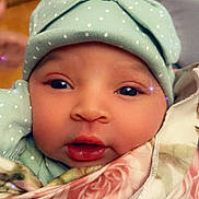 Winter is registered to the contest to win money with this photo: baby, infant, face, hat, polka_dot, blanket, floral, closeup, cute, eyes, skin, mouth, cheeks, headwear, soft, indoors, portrait, sparkles, warm, cozy