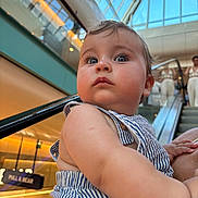 Charli a rejoint le concours — aidez-le/la à gagner de superbes lots ! baby, child, striped_clothing, mall, indoor, escalator, curious, wide_eyes, portrait, person, blue_eyes, skin, short_hair, holding, shopping_center, modern, daylight, close_up, human, casual