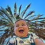 baby, child, smiling, happy, portrait, outdoor, blue_sky, palm_tree, sunlight, nature, person, cute, laughing, toddler, clothing, hand, summer, holiday, fun, cheerful