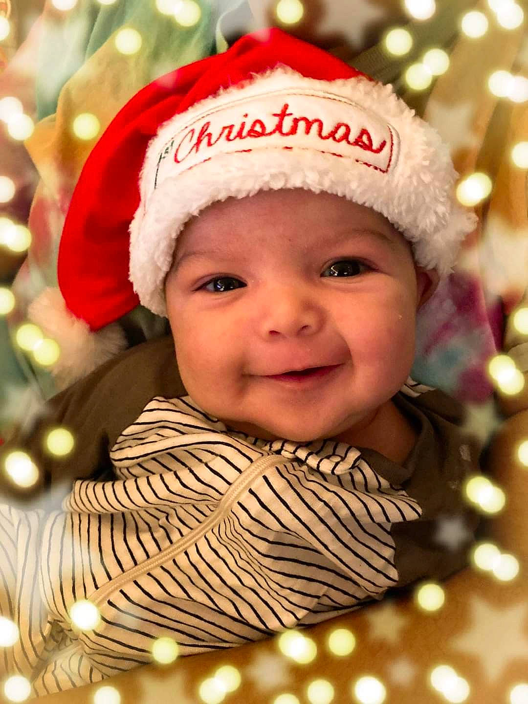 Isaac is registered to the contest to win money with this photo: baby, cheek, christmas_decoration, christmas_ornament, christmas_tree, event, eye, happy, head, headwear, holiday, holiday_ornament, human_body, joy, light, ornament, people_in_nature, person, shortstraw_pine, smile