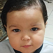 Issac joined the competition — help win amazing prizes! toddler, child, face, portrait, indoor, hair, curly_hair, skin, eyes, expression, clothing, shirt, floor, tile, carpet, person, young_child, cute, baby, head