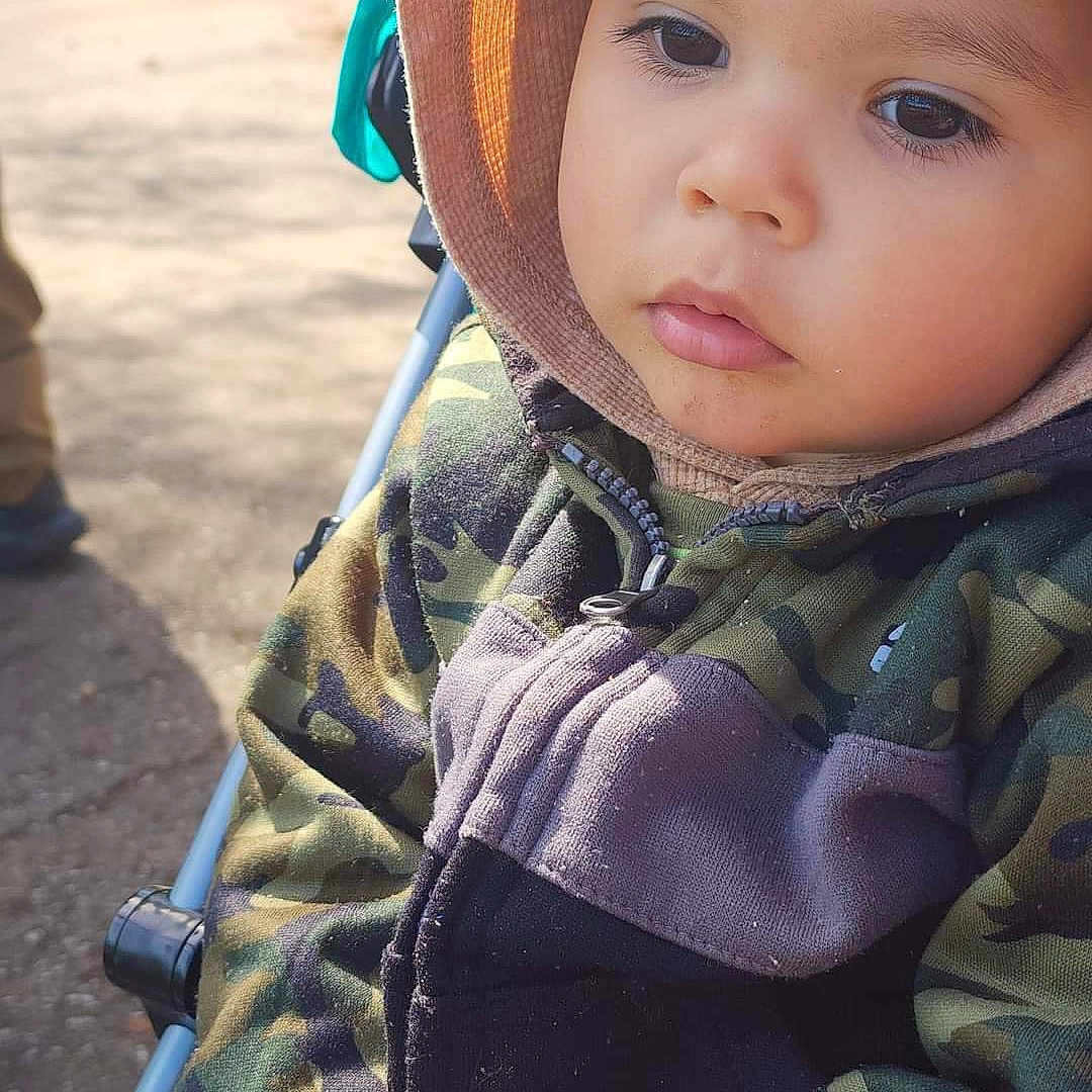Raphael is registered to the contest to win money with this photo: baby, bonnet, cap, clothing, coat, crawling, face, hat, head, hood, hoodie, jacket, knitwear, pants, person, photography, portrait, sleeve, sweater, sweatshirt