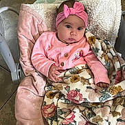 Valeria is registered to the contest to win money with this photo: baby, baby_seat, big_eyes, blanket, bouncer, bow, cardigan, cheeks, cozy, fingertips, floral_blanket, gaze, hand, headband, indoor, infant, pink_clothing, plush, portrait, tiled_floor