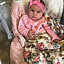 baby, baby_bouncer, baby_seat, blanket, button, cheeks, child, cozy, eyes, floral_blanket, hand, headband, indoor, infant, patterned_textile, pink_bow, pink_clothes, plush_lining, portrait, tile_floor