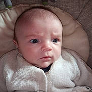 Paul a rejoint le concours — aidez-le/la à gagner de superbes lots ! baby, infant, newborn, face, blue_eyes, surprised_expression, furrowed_brows, blanket, cushion, onesie, drool, chubby_cheeks, head, closeup, indoor, soft_texture, plush_toy, stroller, portrait, clothing