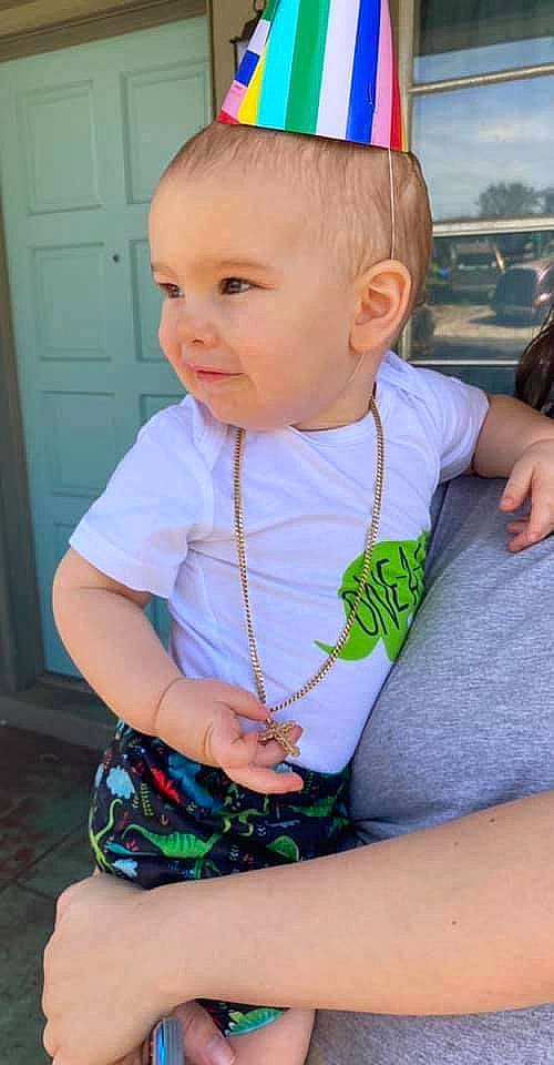 Waylon is registered to the contest to win money with this photo: baby, baby_toddler_clothing, blue, child, chin, cool, door, eye, facial_expression, fun, hairstyle, happy, head, organ, party_hat, person, skin, sleeve, smile, standing