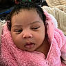 baby, infant, child, portrait, face, curly_hair, pink_jacket, fleece, blanket, cozy, indoor, close_up, looking_at_camera, serious_expression, soft_lighting, couch, home, snuggled, photography, cute