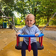 Servane a rejoint le concours — aidez-le/la à gagner de superbes lots ! child, toddler, swing, playground, park, trees, autumn, outdoor, blue_sweater, navy_leggings, brown_shoes, happy, smiling, daylight, chains, play_equipment, nature, leaves, cute, person
