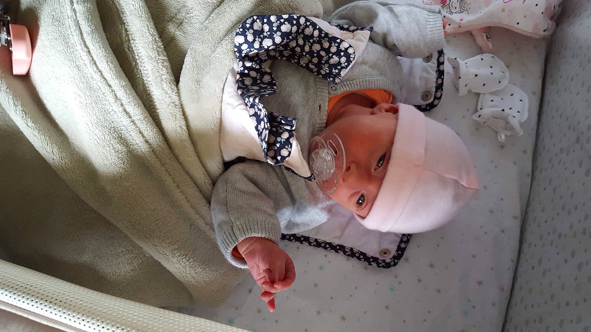 Chloé a rejoint le concours — aidez-le/la à gagner de superbes lots ! baby, baby_products, baby_safety, baby_sleeping, baby_toddler_clothing, child, comfort, fashion_accessory, finger, hat, headgear, headpiece, headwear, linens, pattern, person, pink, room, skin, sleeve